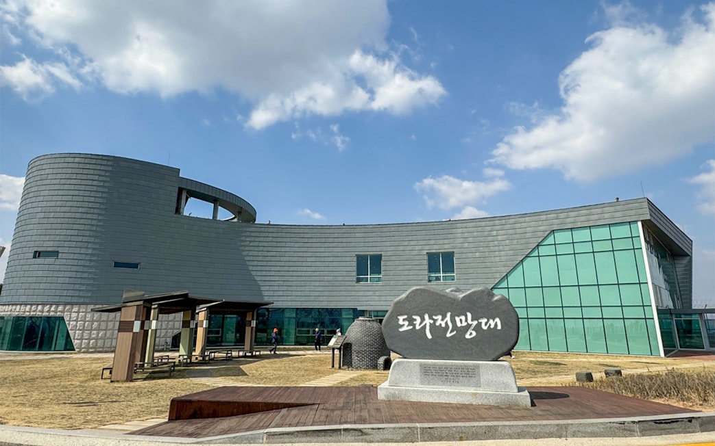 Exterior of Dora Observatory building at the DMZ, South Korea, with stone sign in foreground.