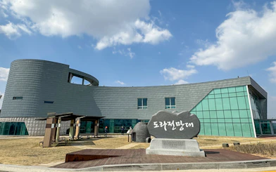 Exterior of Dora Observatory building at the DMZ, South Korea, with stone sign in foreground.