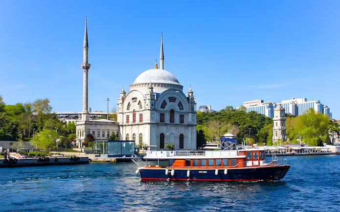 Bosphorus cruise boat passing Dolmabahçe Mosque in Istanbul.