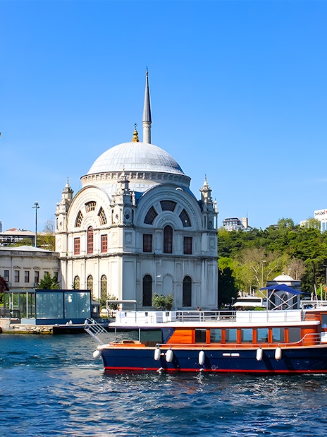 Bosphorus cruise boat passing Dolmabahçe Mosque in Istanbul.