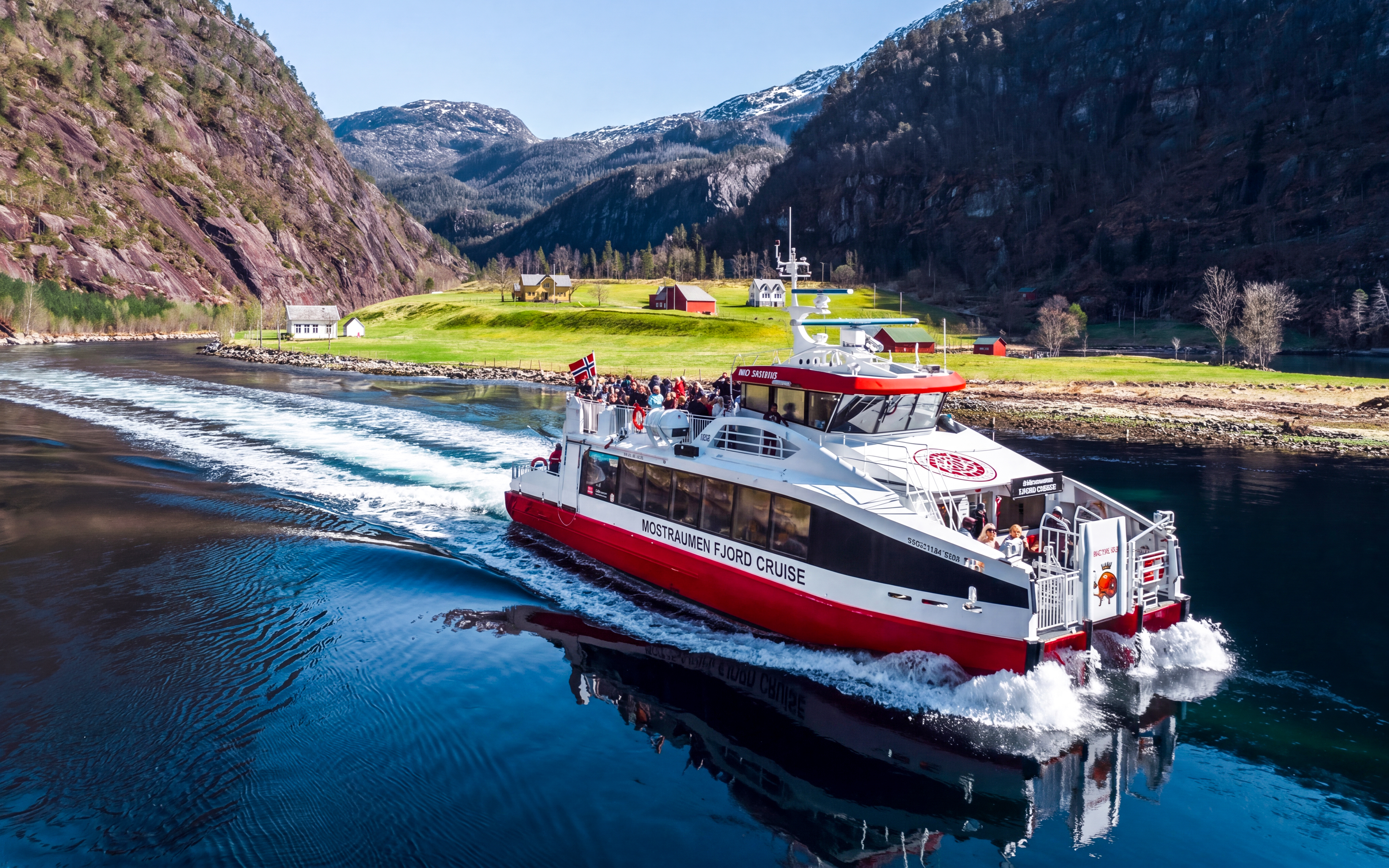 Cruise boat on Mostraumen Fjord near Bergen with scenic mountain views.