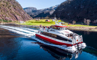 Cruise boat on Mostraumen Fjord near Bergen with scenic mountain views.