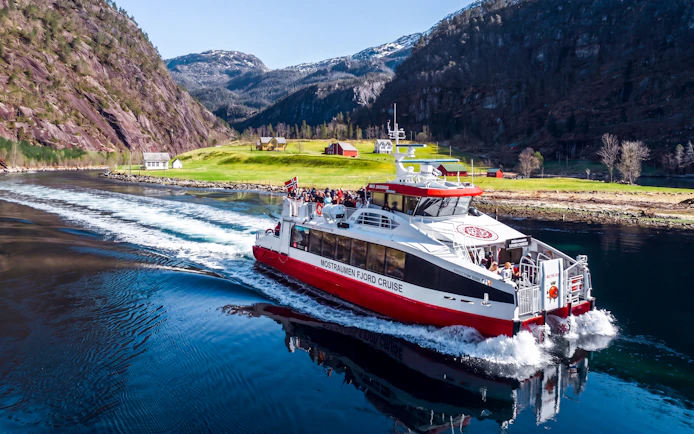 Cruise boat on Mostraumen Fjord near Bergen with scenic mountain views.