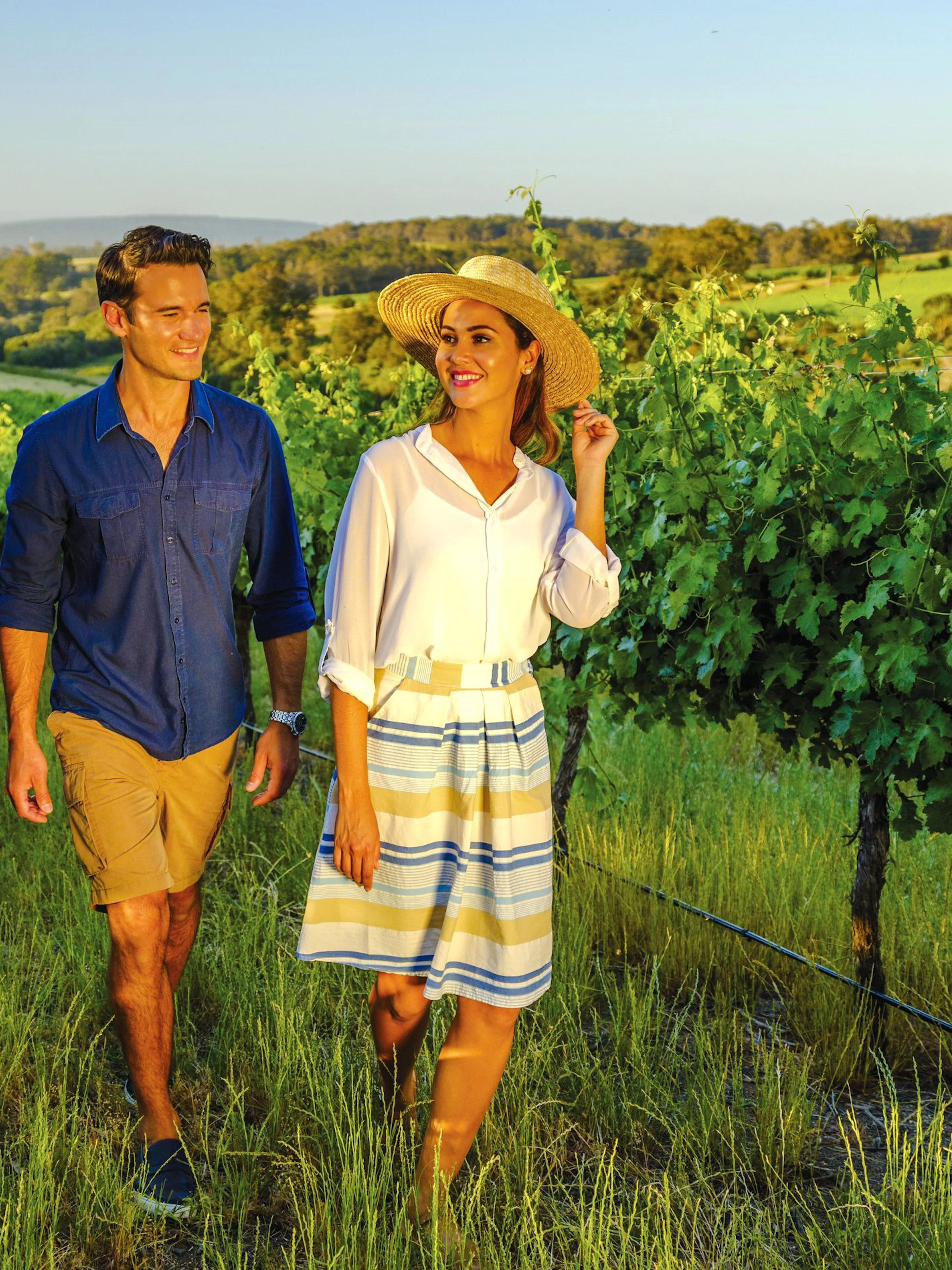 Couple walking through vineyard at sunset on Yarra Valley Small Group Tour.
