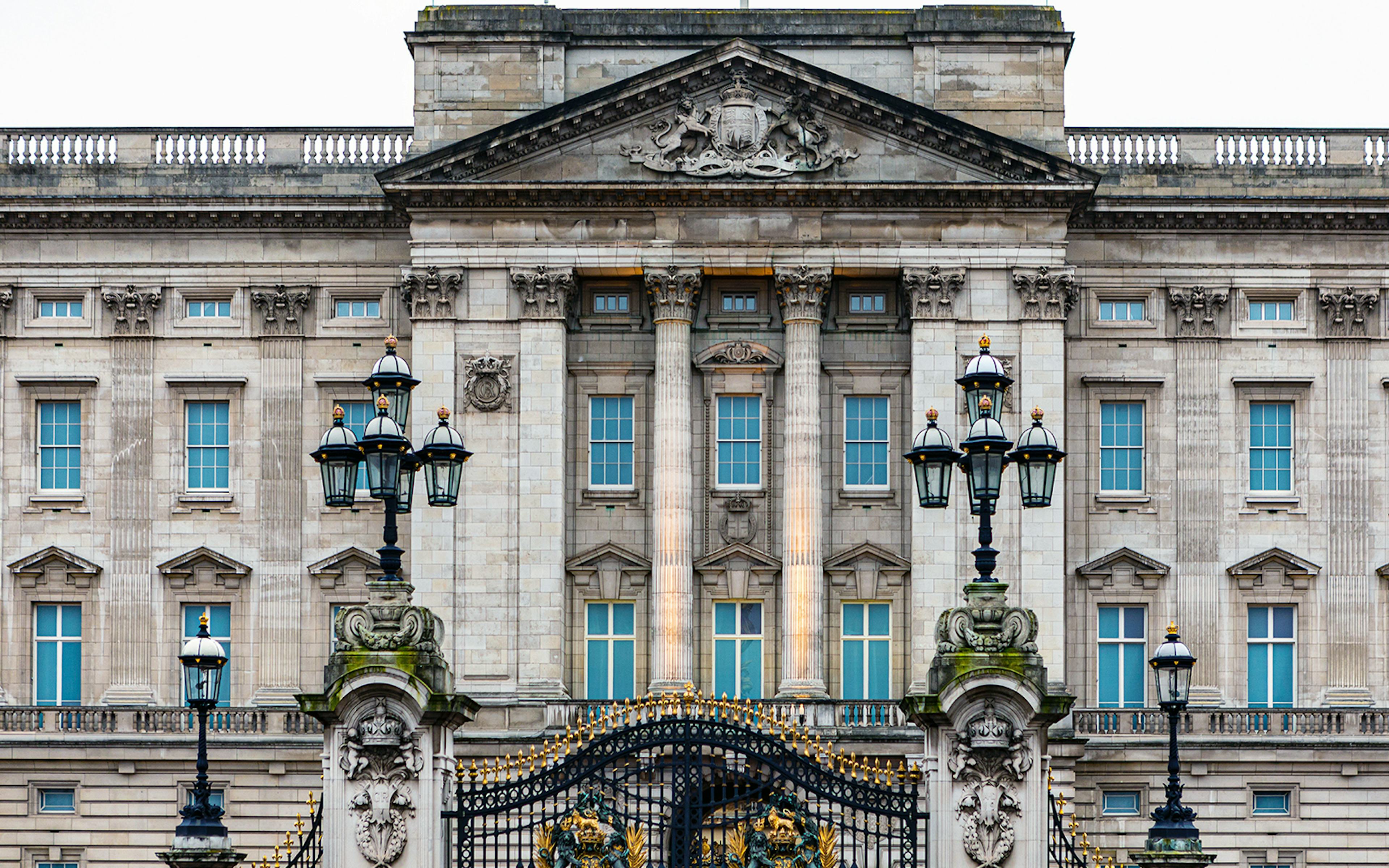 Buckingham Palace facade with ornate gates and historical architecture.