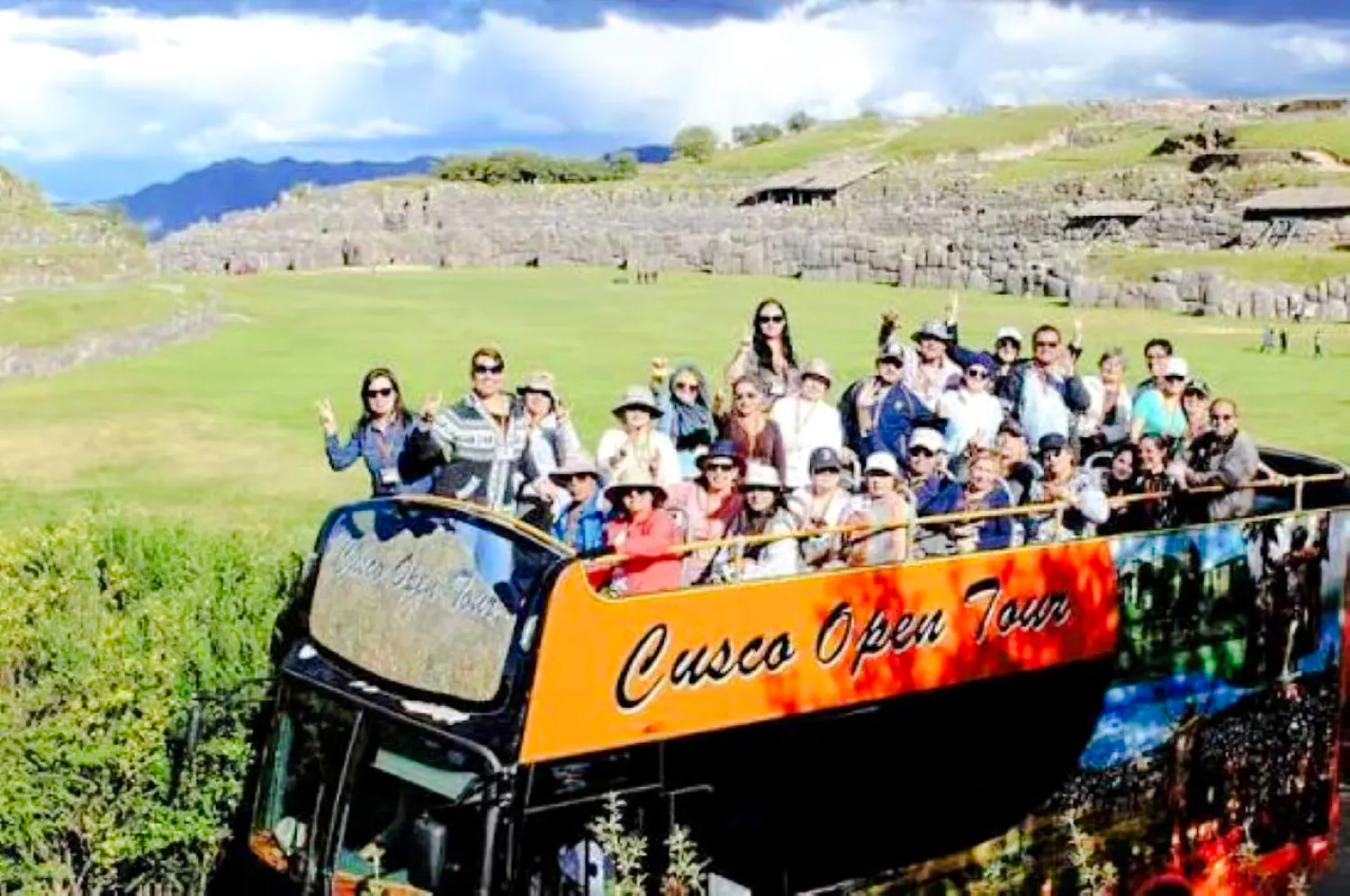 Tourists on an open-top bus at Sacsayhuamán ruins, Cusco.