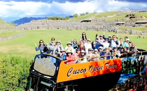 Tourists on an open-top bus at Sacsayhuamán ruins, Cusco.