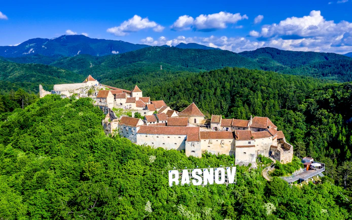 Rasnov Fortress surrounded by lush green forests in Brasov, Transylvania.