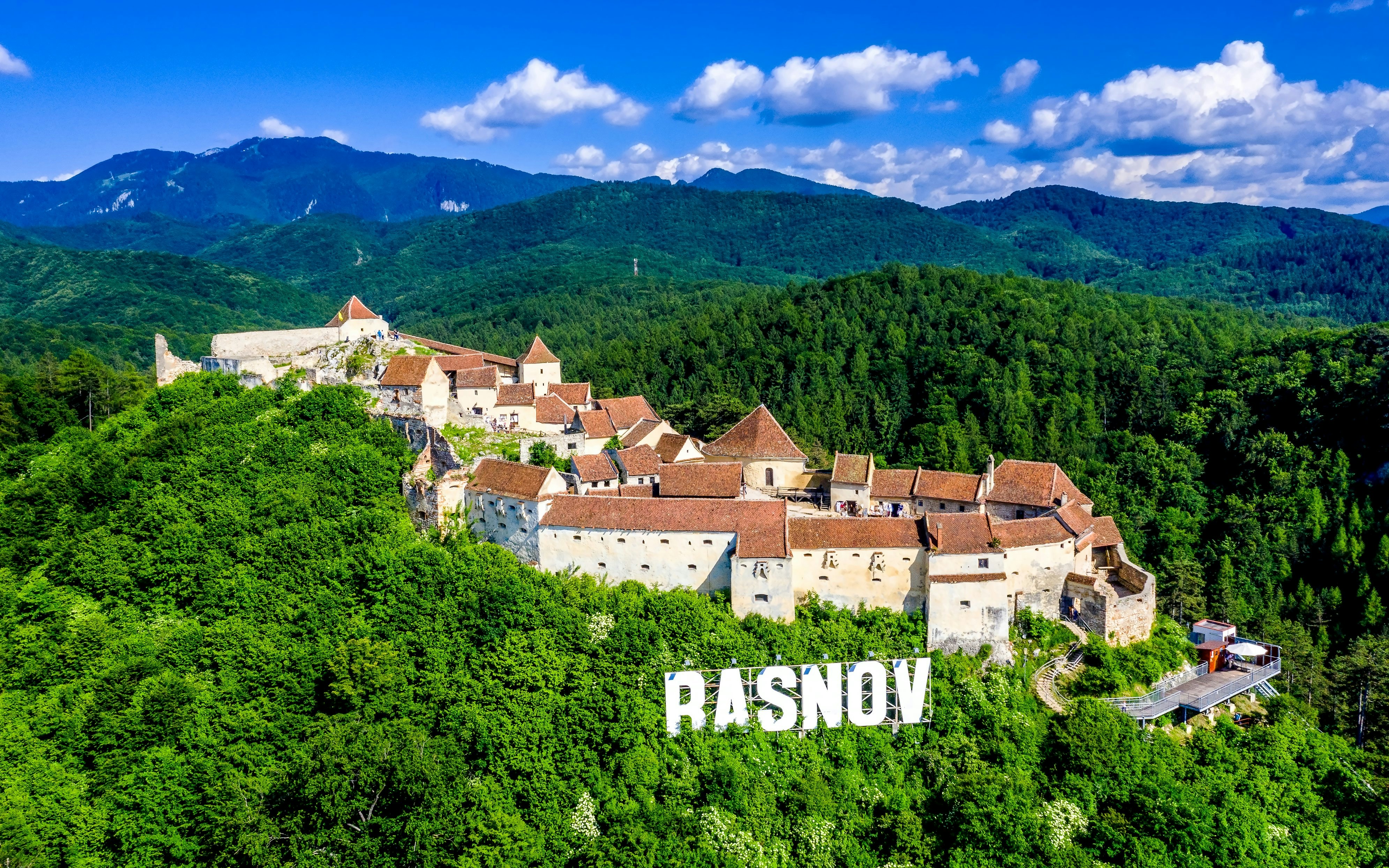 Rasnov Fortress surrounded by lush green forests in Brasov, Transylvania.