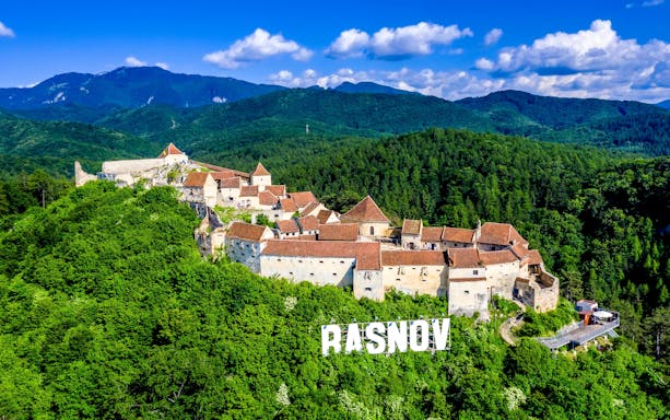 Rasnov Fortress surrounded by lush green forests in Brasov, Transylvania.