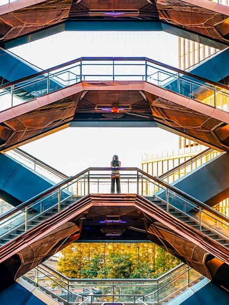 Vessel structure in New York City with visitors on staircases at sunset.