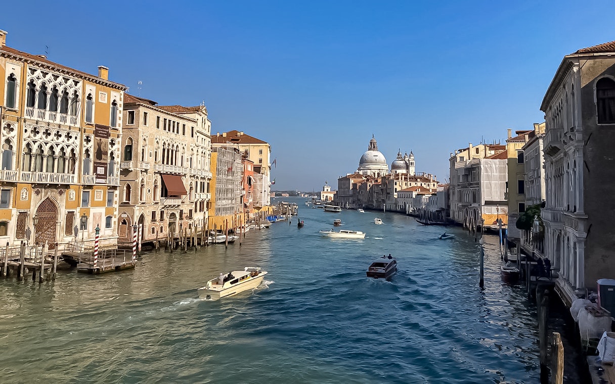 Sightseeing boats on Venice's Grand Canal with Santa Maria della Salute in view.