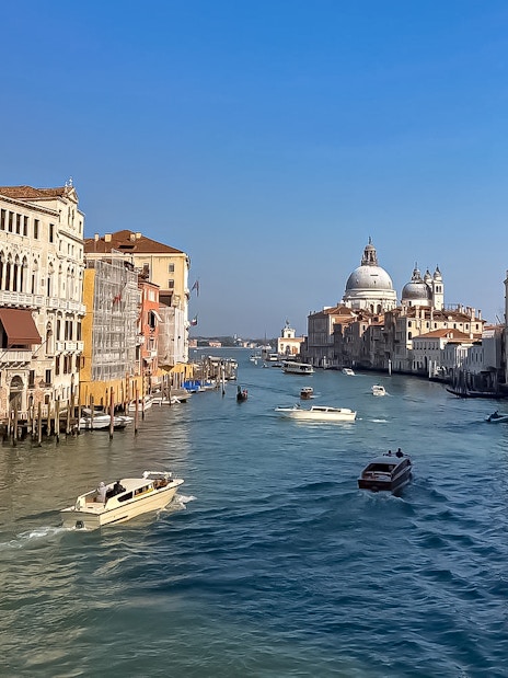 Sightseeing boats on Venice's Grand Canal with Santa Maria della Salute in view.