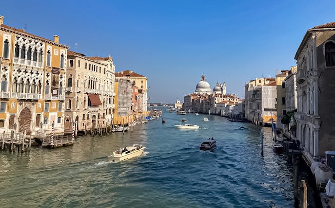 Sightseeing boats on Venice's Grand Canal with Santa Maria della Salute in view.