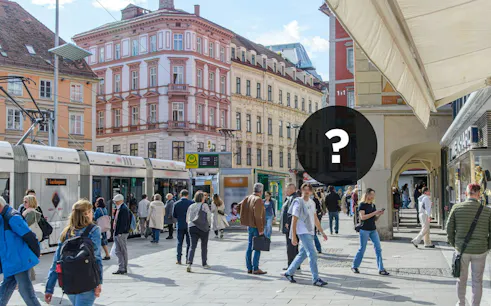 Pedestrians and tram in Graz city center during self-guided exploration game.