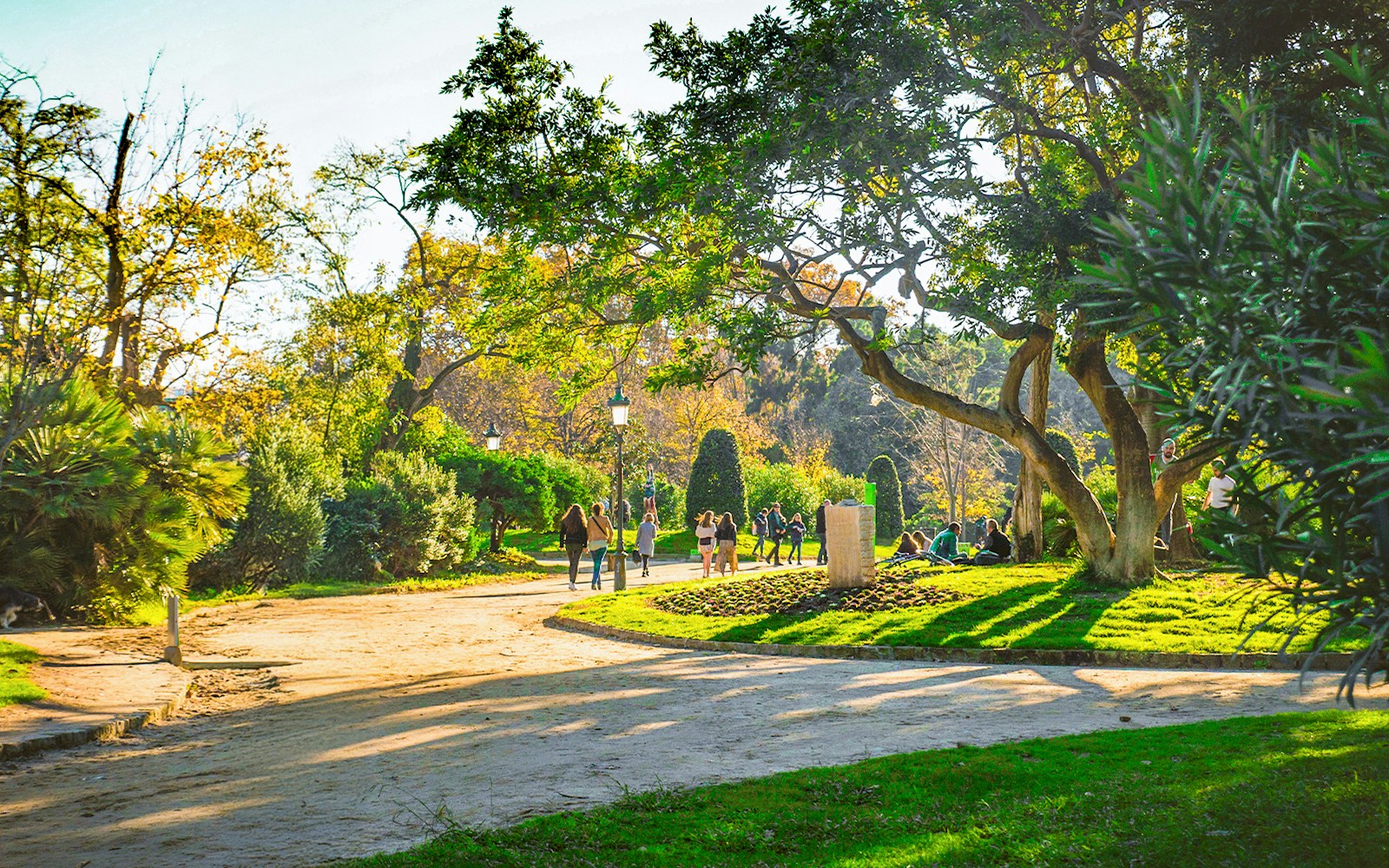 Pathway with people and green trees in Ciutadella Park, Barcelona.