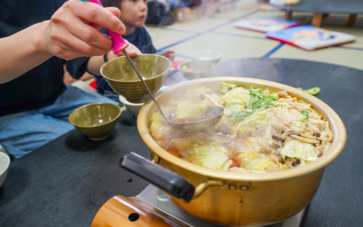 Steaming hot pot with vegetables and mushrooms served during Sumo Wrestling Experience in Tokyo.