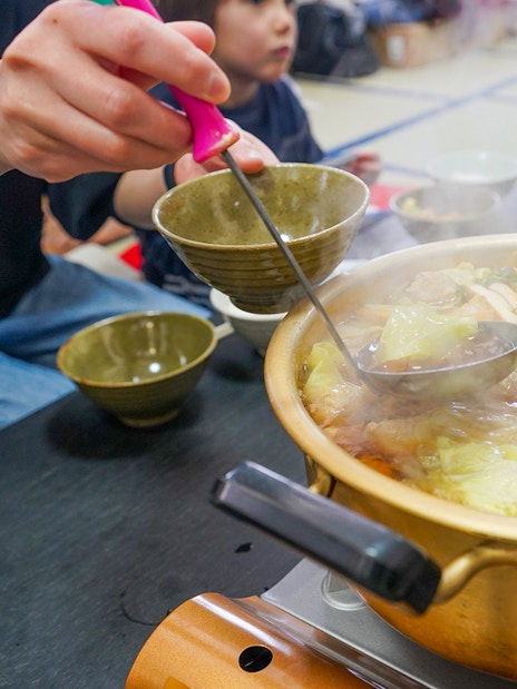 Steaming hot pot with vegetables and mushrooms served during Sumo Wrestling Experience in Tokyo.