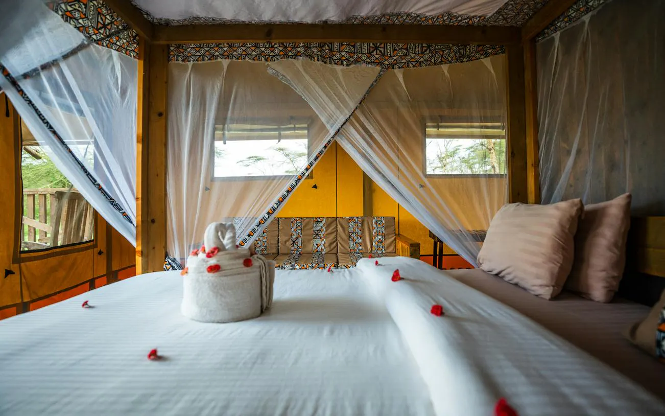 Safari tent interior with bed and decorative towels, part of the 5-Day Tarangire, Serengeti, Ngorongoro tour.