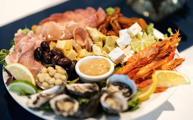 Seafood platter with prawns, oysters, cheese, and olives on Darwin Harbour Sunset Dinner Cruise.