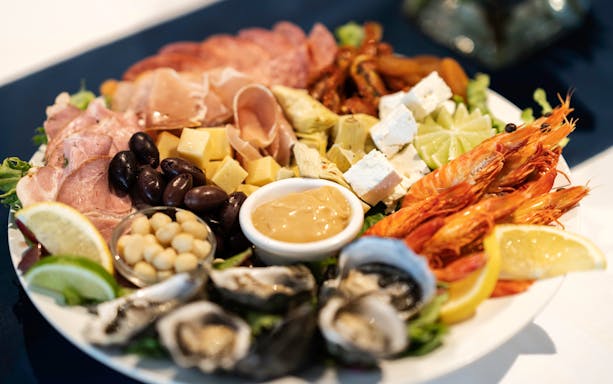 Seafood platter with prawns, oysters, cheese, and olives on Darwin Harbour Sunset Dinner Cruise.