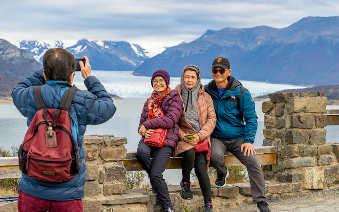 Visitors posing at the Perito Moreno Glacier viewing deck in Argentina.