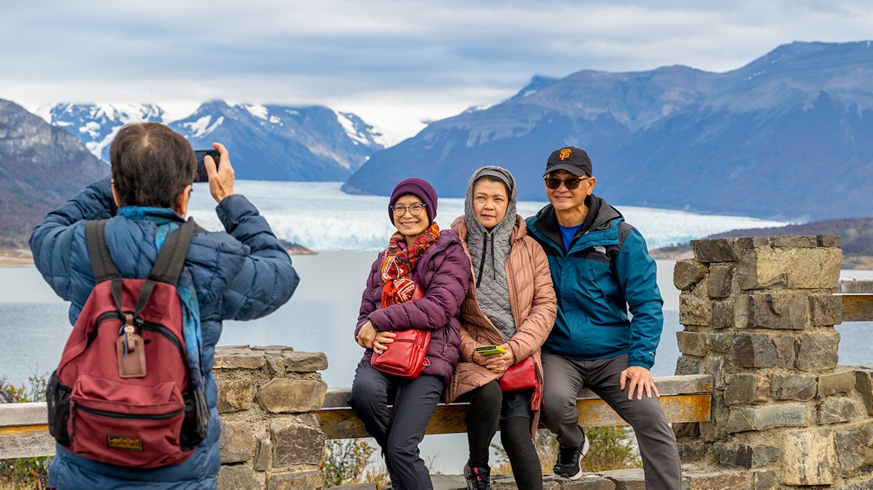 Visitors posing at the Perito Moreno Glacier viewing deck in Argentina.