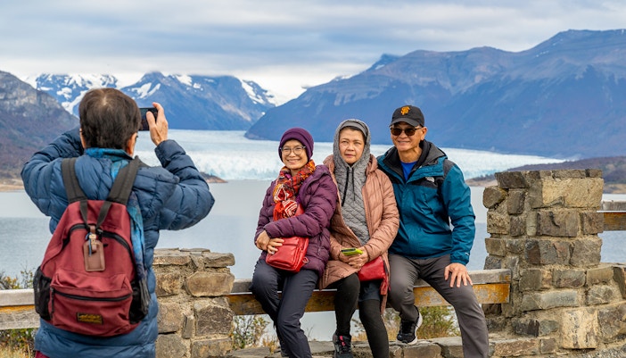 Visitors posing at the Perito Moreno Glacier viewing deck in Argentina.
