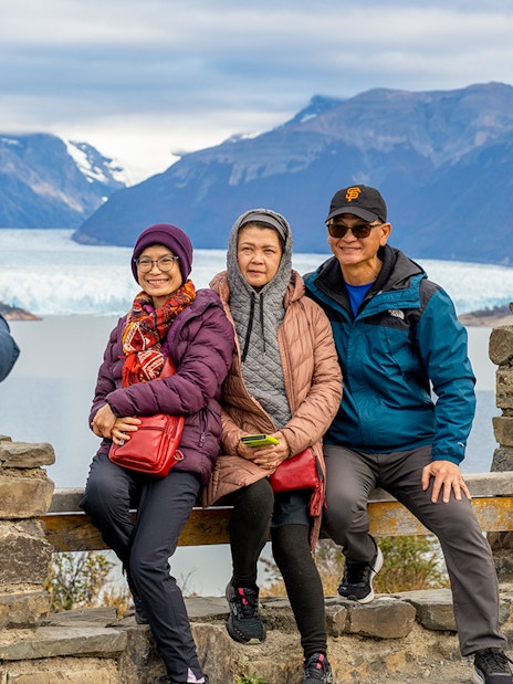 Visitors posing at the Perito Moreno Glacier viewing deck in Argentina.
