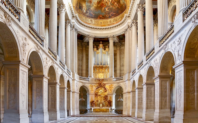 Royal Chapel interior with ornate columns and grand organ, Palace of Versailles.