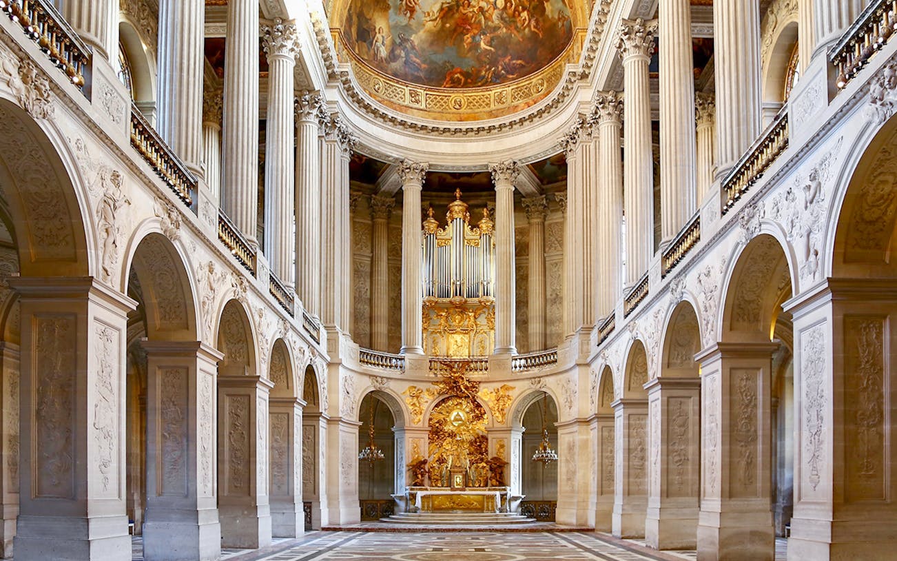 Royal Chapel interior with ornate columns and grand organ, Palace of Versailles.