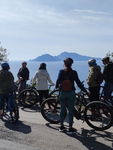 Group on e-bikes overlooking the sea during Mount Vesuvius tour from Sorrento.