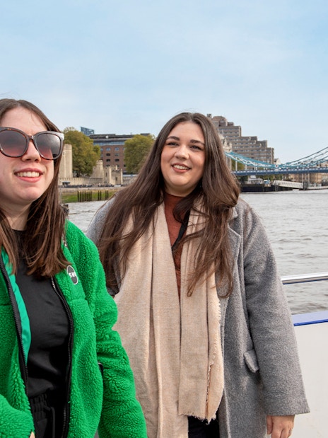 Women enjoying a Thames River afternoon cruise with Tower Bridge in the background.