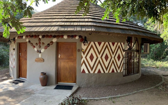 Traditional round hut with geometric patterns in Durban, part of a private tour package.
