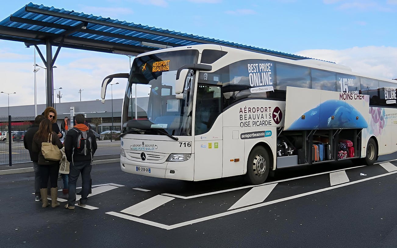 People loading luggage into side storage of Aerobus Paris Airport Transfer.