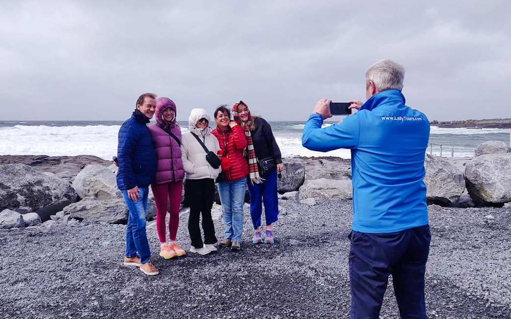 Group posing for a photo on a rocky shore during a guided tour in the Burren.