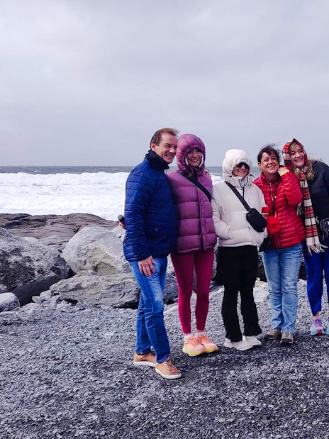 Group posing for a photo on a rocky shore during a guided tour in the Burren.