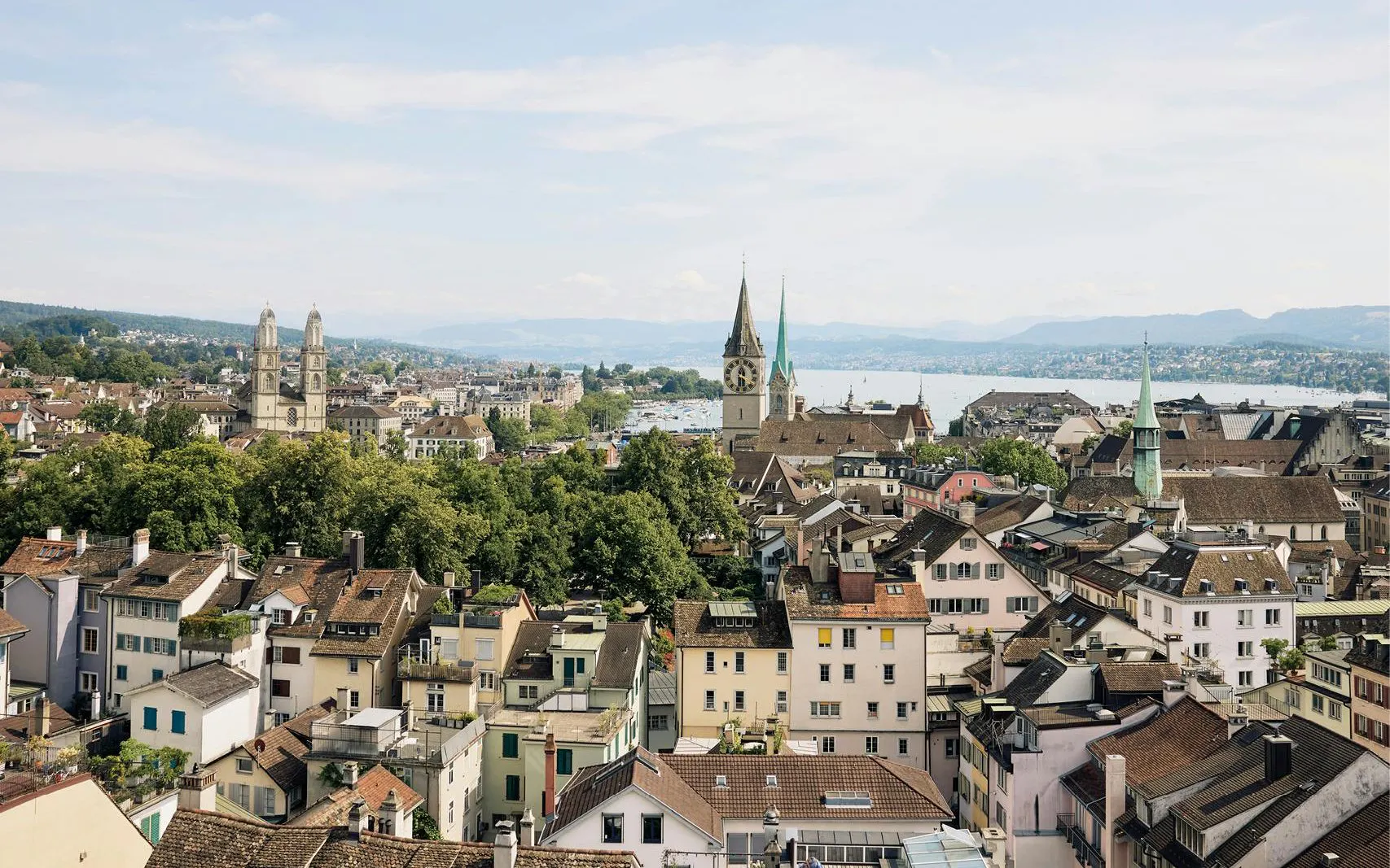 Panoramic view of Zurich's old town with historic churches and Lake Zurich in the background.