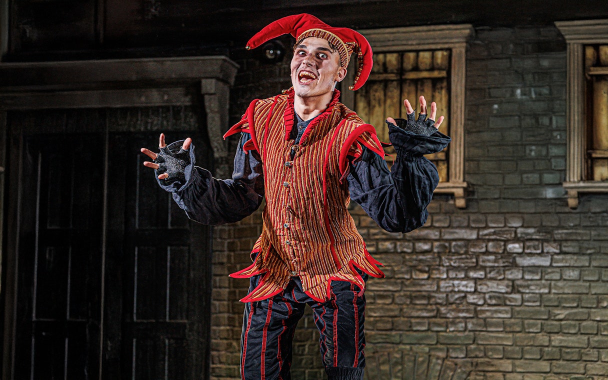 Performer in jester costume at London Dungeon VIP experience.