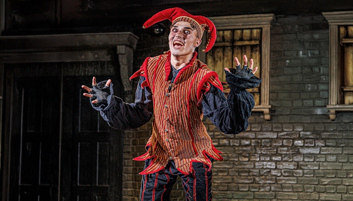 Performer in jester costume at London Dungeon VIP experience.