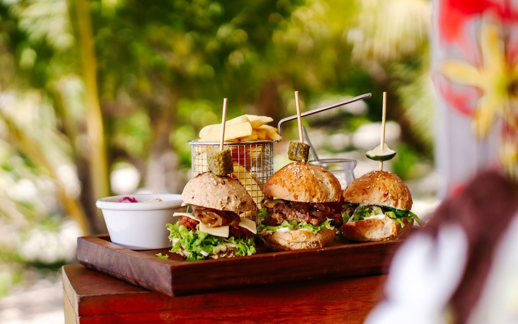Sliders and fries on a wooden tray at Malamala Beach Club, Fiji.
