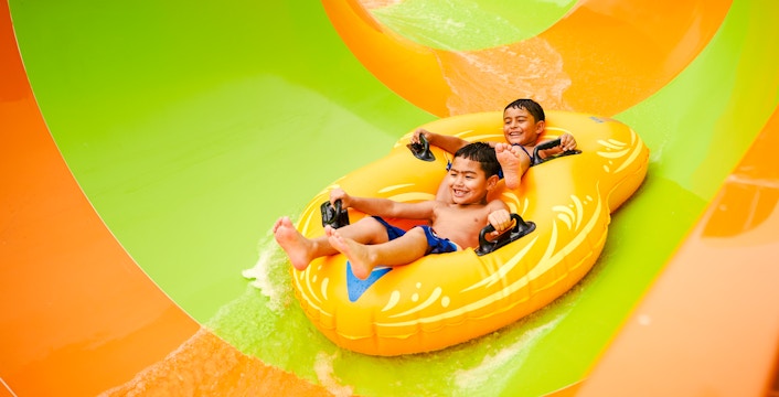 Children enjoying a water slide at Hurricane Harbor, Six Flags Arlington.