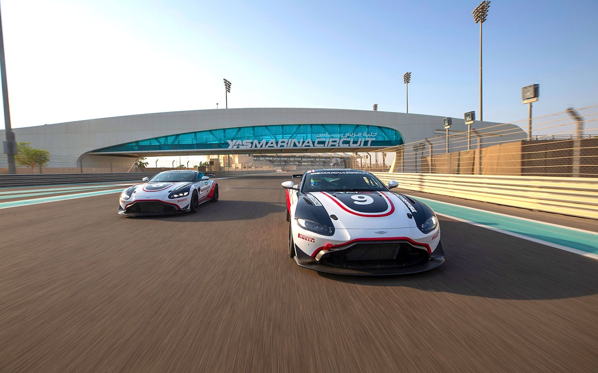 Aston Martin GT4 cars racing at Yas Marina Circuit in Abu Dhabi.