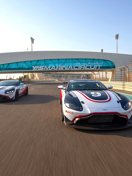 Aston Martin GT4 cars racing at Yas Marina Circuit in Abu Dhabi.