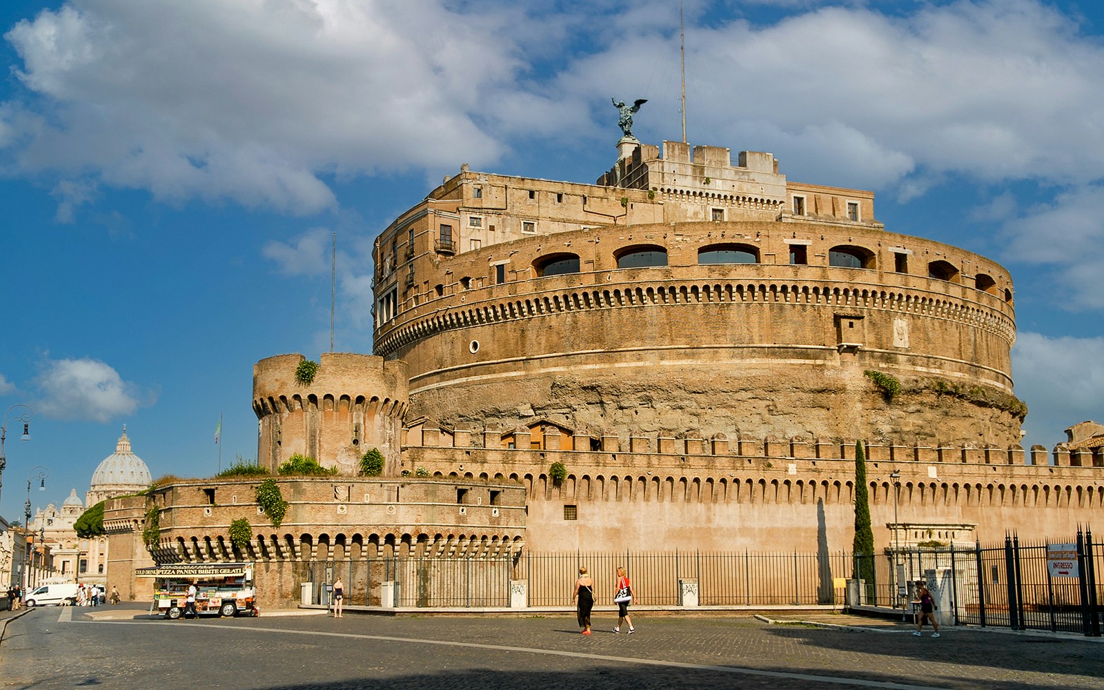 Castel Sant'Angelo exterior view in Rome, Italy, with tourists walking nearby.