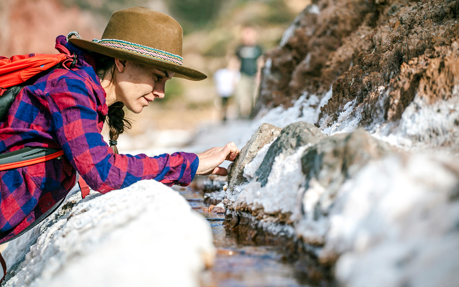 Visitor exploring salt ponds at Maras Salt Mines, Sacred Valley, Peru.