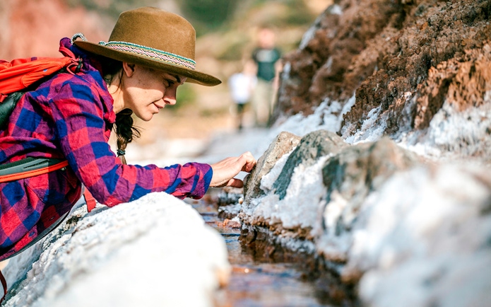 Visitor exploring salt ponds at Maras Salt Mines, Sacred Valley, Peru.