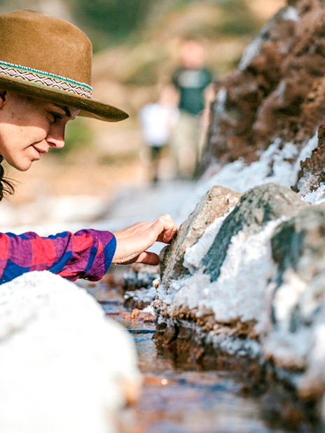 Visitor exploring salt ponds at Maras Salt Mines, Sacred Valley, Peru.