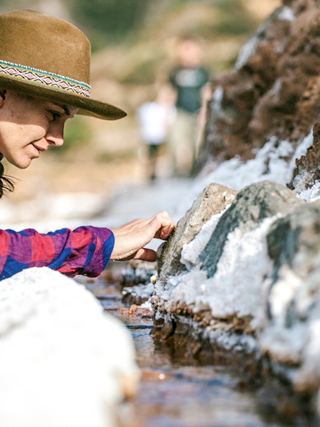 Visitor exploring salt ponds at Maras Salt Mines, Sacred Valley, Peru.