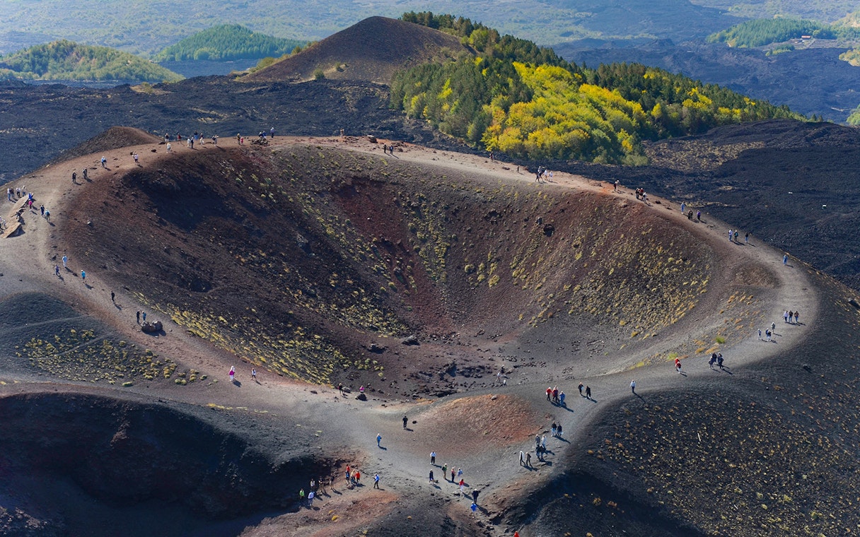 Hikers exploring the rim of Mount Etna Crater in Sicily, Italy.